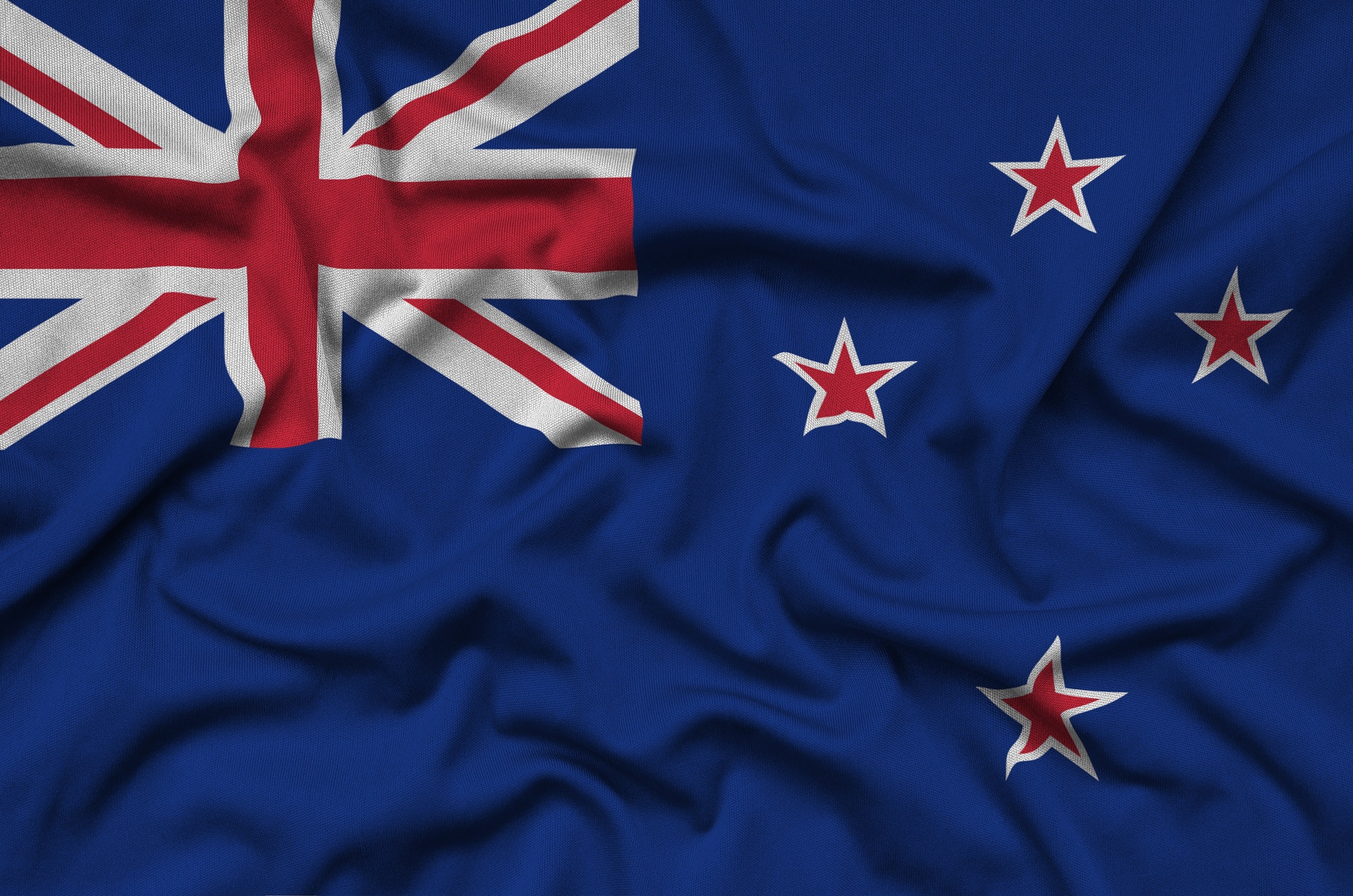 New Zealand flag is depicted on a sports cloth fabric with many folds. Sport team waving banner