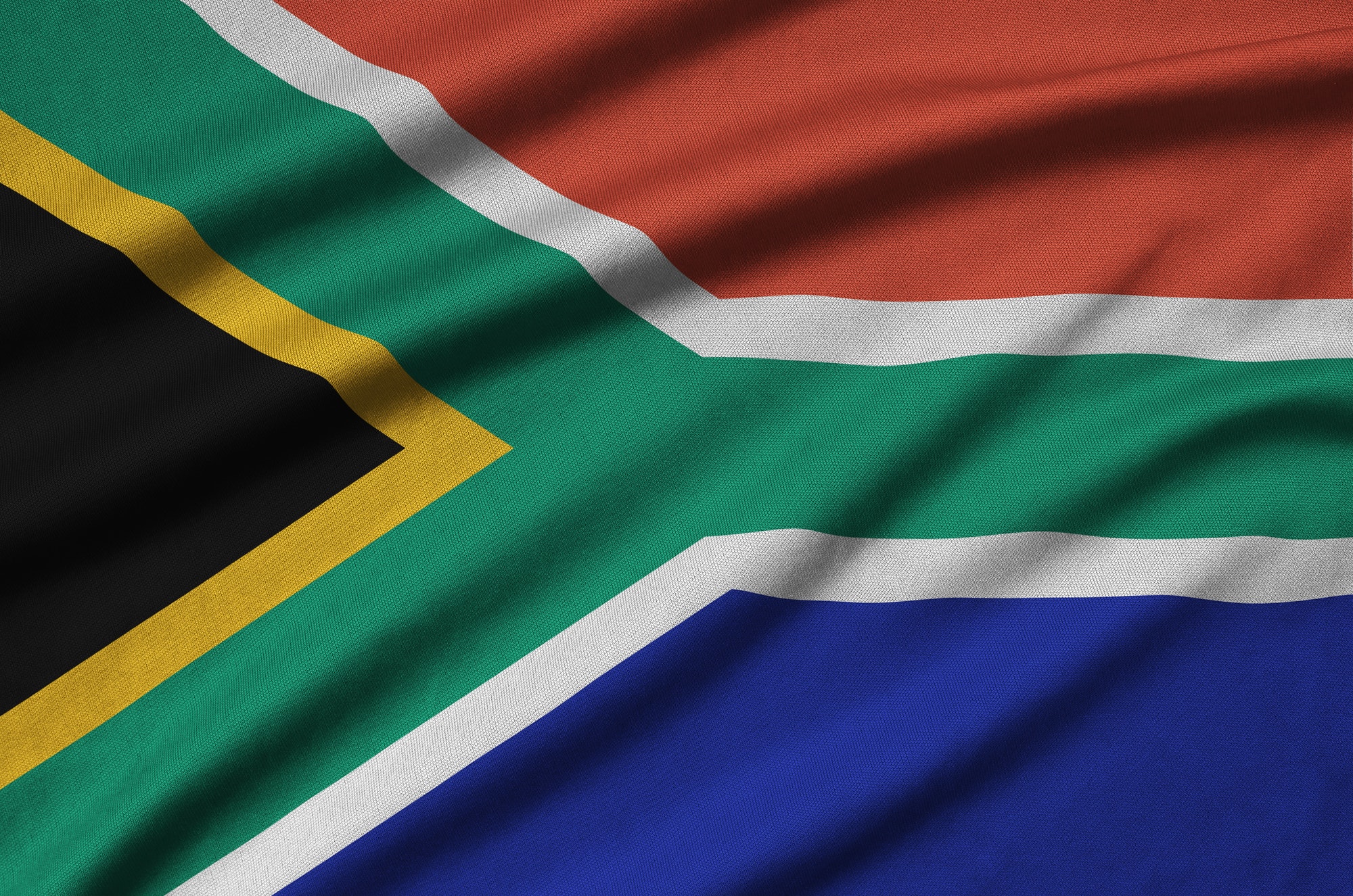 South Africa flag is depicted on a sports cloth fabric with many folds. Sport team waving banner